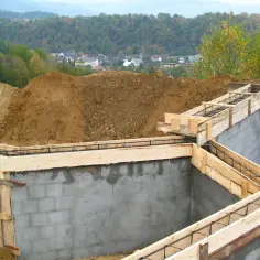 Fundamenty domu w budowie, zbrojenie i szalunki czekają na beton. Ważne jest pozwolenie na budowę, by wszystko szło zgodnie z planem.