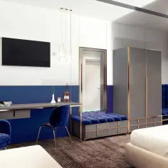 Nowoczesny pokój z meblami w głębokim, szafirowym kolorze. Wygodny fotel i siedzisko zapraszają do odpoczynku.