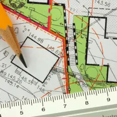 Ołówek i linijka na mapie geodezyjnej. Widoczne linie, oznaczenia wysokości i numer działki ewidencyjnej.