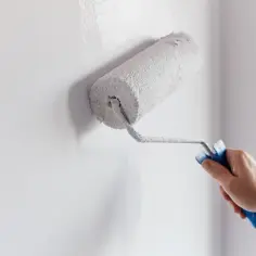Malowanie ściany wałkiem. Czekam aż grunt schnie, by położyć kolejną warstwę farby.