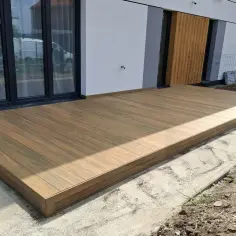 Nowy taras na słupach betonowych, wykonany z desek kompozytowych, stanowi idealne przedłużenie domu.