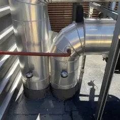Izolowane rury z manometrami, być może transportujące glikol, na dachu.