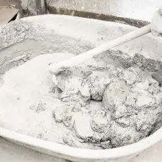 Mieszanie wapna gaszonego z wodą w dużej misie, tworząc gładką masę do tynkowania.