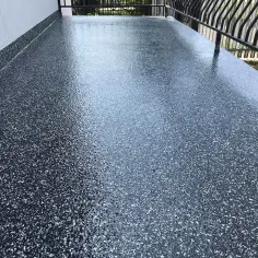 Nowoczesna żywica na balkon cena za metr. Ciemna, błyszcząca posadzka z drobinkami.