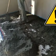 Prace przy wylewce podłogowej. Widać materiał do wykonania dylatacji posadzki i rury instalacyjne.
