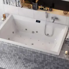 Nowoczesna łazienka z wanną do hydromasażu, świecami i stosikiem ręczników.