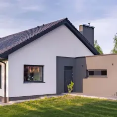 Nowoczesny dom z białymi i grafitowymi akcentami, prezentujący najmodniejsze kolory elewacji.
